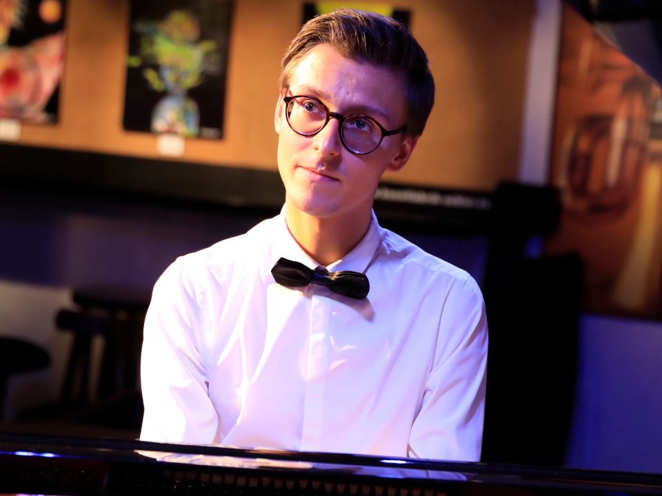 Pianist sitzt vor einem Flügel